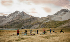 people doing yoga in french alps at sunrise