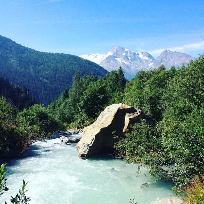 glacial melt water stream with big rock and mountain views France