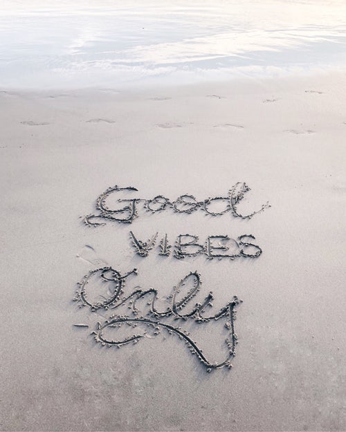 good vibes written in sand
