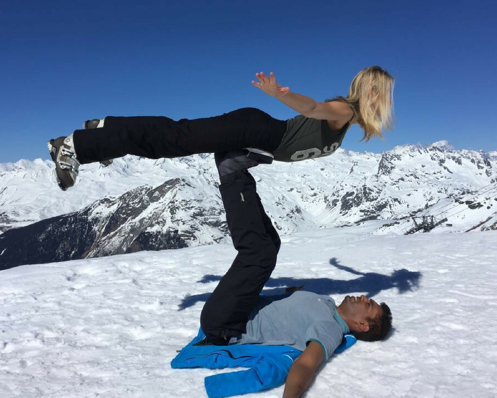 partner yoga pose with two people in snow