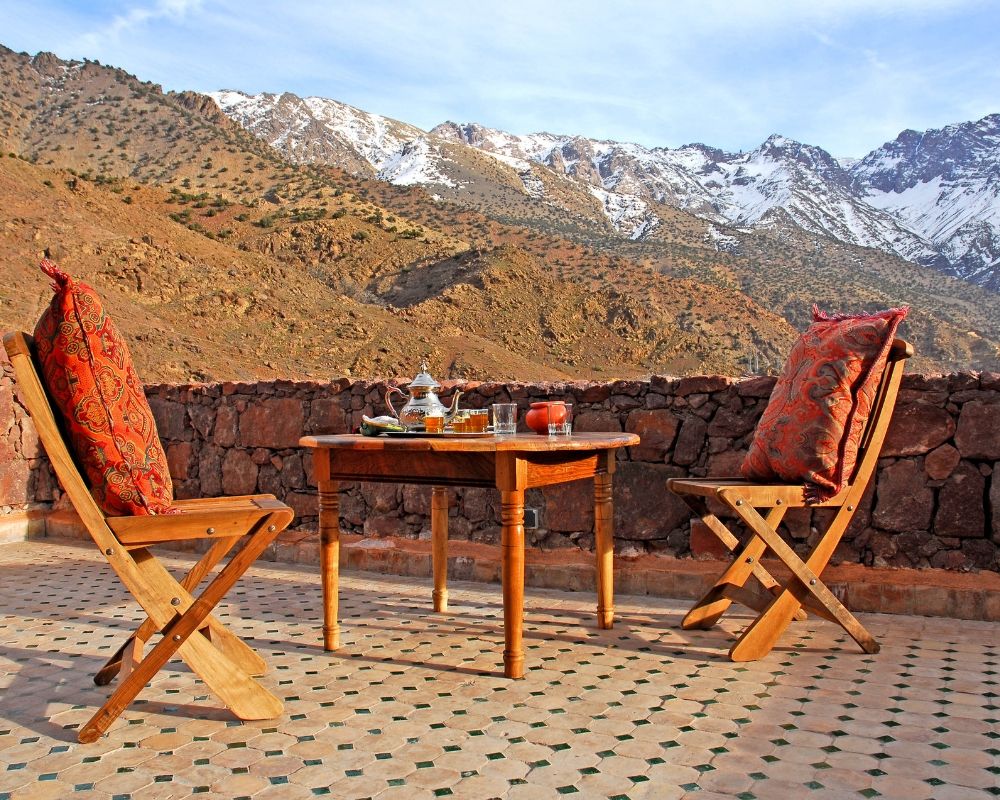 two charis and table in atlas snowcapped mountains