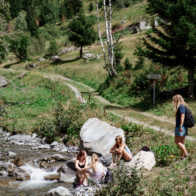 women resting by stream french alps