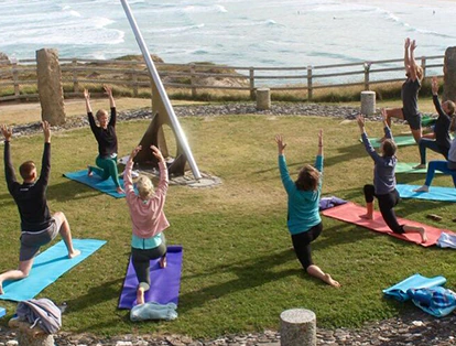 People are doing yoga on the seaside