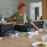 woman at table holding plated food