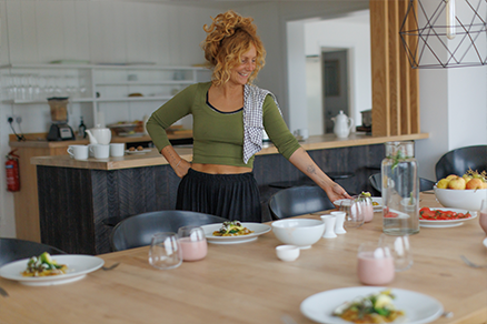 woman at table holding plated food