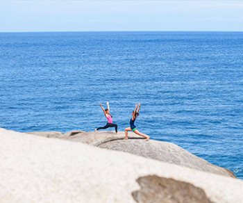 two people yoga and sea