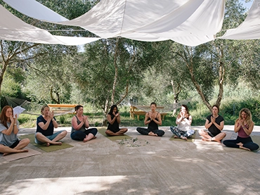 people doing outdoor yoga seated position