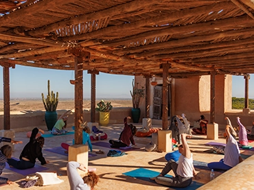 people doing yoga on a rooftop terrace in morocco