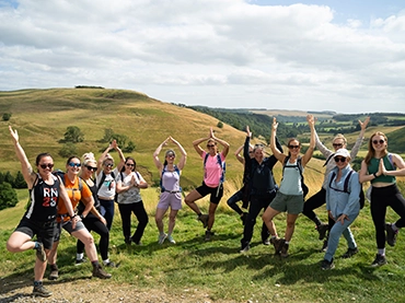 group of people doing a yoga pose at the top of a hill in yorkshire