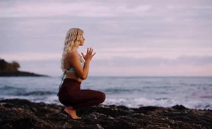 woman doing yoga by the sea