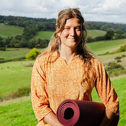 yoga teacher with green hills in the background