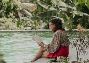 lady reading a book with her feet in the pool in sri lanka